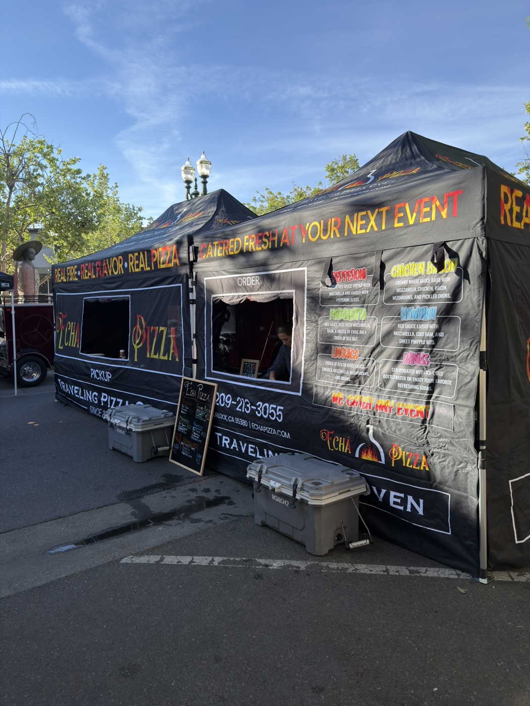 Echa Pizza tent and fire truck setup at an event